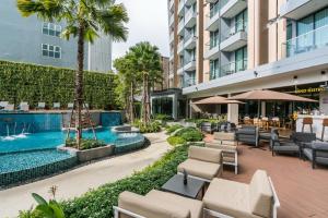 芭堤雅市中心Hotel Amber Pattaya的酒店庭院设有躺椅和游泳池