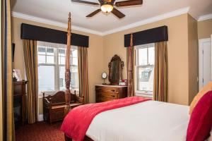 纽波特Almondy Inn Bed & Breakfast的一间卧室配有一张床和吊扇
