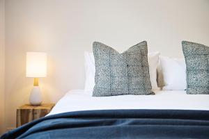 马奇The Laneway的一间卧室配有一张带蓝色床单和枕头的床。