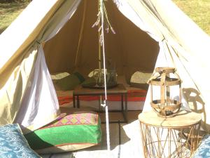 红山南Iluka Retreat Glamping Village的帐篷,配有桌子和灯