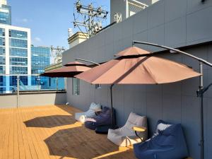 釜山The Stone Bridge Hotel Sasang的一座带椅子和遮阳伞的庭院