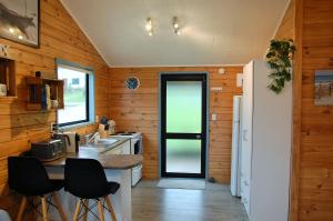 奥波诺尼Opononi Bliss的厨房设有木墙和白色冰箱。