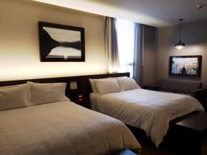 瓜达拉哈拉Staybridge Suites - Guadalajara Novena, an IHG Hotel的酒店客房设有两张床和窗户。