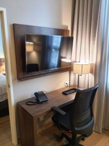 瓜达拉哈拉Staybridge Suites - Guadalajara Novena, an IHG Hotel的一张桌子,在酒店的房间里,带电话和椅子