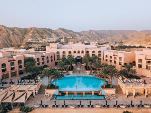 马斯喀特Shangri-La Al Husn, Muscat - Adults Only Resort的享有度假村的空中景致,设有游泳池和棕榈树