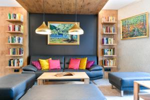 科特布斯Best Western Plus Parkhotel & Spa Cottbus的客厅配有蓝色沙发及色彩缤纷的枕头