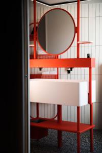 多维尔YOU Are Deauville的红色的架子,上面有镜子和水槽