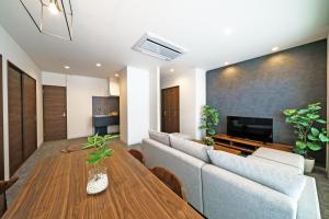 大阪STAY & GO Shinsaibashi-Kita的客厅配有沙发和桌子