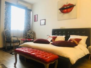 阿比让Hotel Le Griffon的一间卧室配有一张大床,墙上挂着红唇画