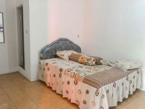 井里汶Rumah Panggung Guest House Syariah Mitra RedDoorz的床上有毯子和枕头