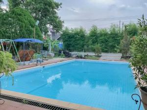 井里汶Rumah Panggung Guest House Syariah Mitra RedDoorz的院子里的大型蓝色游泳池
