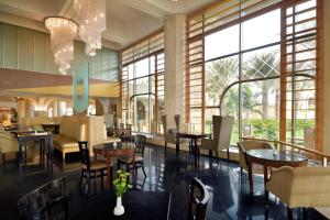 吉达吉达洲际酒店的餐厅设有桌椅和窗户。