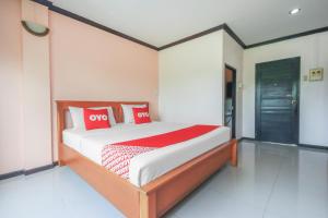 洛坤府OYO 1145 Prickhom Garden Hotel的一间卧室配有红色和白色枕头的床