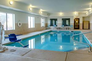 霍布斯Sleep Inn & Suites的一个带椅子和桌子的大型游泳池