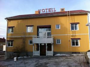 谢莱夫特奥Hotell Stensborg的黄色建筑,上面有酒店标志