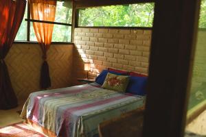 戈亚斯州上帕莱索Mariri Jungle Lodge的一间设有床铺的卧室,位于带窗户的房间内