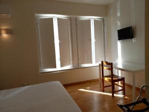 里斯本桑托斯住宿加早餐旅馆的一间卧室配有一张床、一张桌子和一把椅子