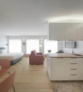 里斯本Lisbon Serviced Apartments - Principe Real的厨房以及带床和柜台的起居室。