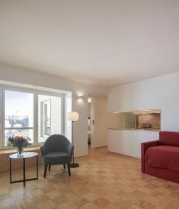 里斯本Lisbon Serviced Apartments - Principe Real的客厅配有红色的沙发和椅子