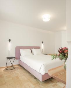 里斯本Lisbon Serviced Apartments - Principe Real的白色卧室配有一张大床和一张桌子