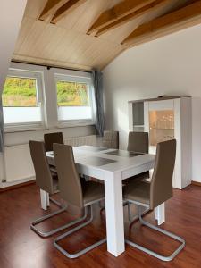 阿尔特瑙Ferienwohnung am Rothenberg的一间配备有白色桌椅的用餐室
