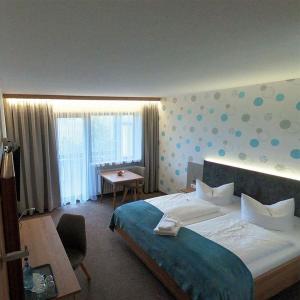 沙伊代格阿尔高加尼酒店的一间卧室配有一张大床、一张桌子和一张桌子