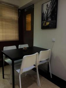 香港Oasis Apartments的餐桌、白色椅子和黑桌