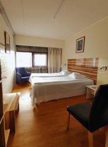 赫尔辛基Arkadia Hotel & Hostel的一间大卧室,配有一张大床和一把椅子