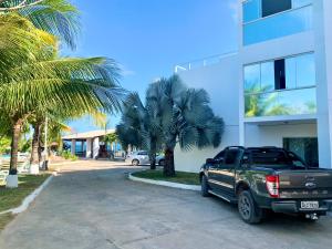 马塞约Pousada Paradise Vista do Atlantico的停在棕榈树建筑前面的卡车