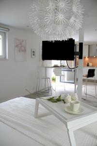 斯普里蒙Appartement Blanc cocooning的白色的客厅配有桌子和电视。