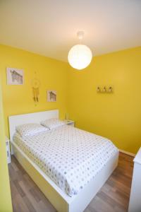 圣康坦Appartement "le Terminus " Gare-Cosy-Wifi 6 Personnes的卧室拥有黄色的墙壁和白色的床。