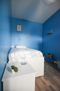 圣康坦Appartement "le Terminus " Gare-Cosy-Wifi 6 Personnes的蓝色的客房配有白色的床和一张桌子