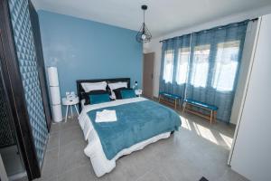 佩皮尼昂Explore the World 1的蓝色的卧室设有一张大床和蓝色的墙壁