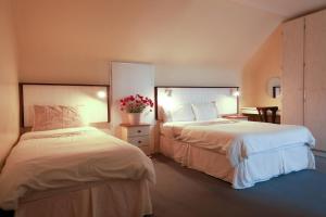 戈尔韦阿拉斯格拉顿公寓的一间酒店客房,配有两张床和鲜花