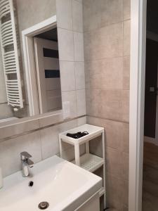 卡托维兹Sun Apartment Katowice Chorzów的浴室设有白色水槽和镜子