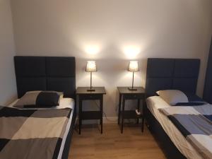 卡托维兹Sun Apartment Katowice Chorzów的两张床位于带两盏挂在墙上的灯的房间