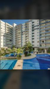 热河市FLAT VEREDAS RIO QUENTE Apto 113的大型公寓大楼,设有游泳池和建筑