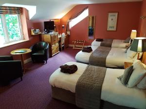 韦斯特波特博芬宾馆的酒店客房设有三张床和电视。
