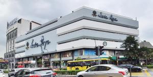 吉隆坡ACES Hotel Kuala Lumpur的前面有一辆公共汽车停靠的建筑