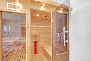 梅顿梅顿5花结酒店的一间铺有木地板并配有玻璃门的桑拿浴室