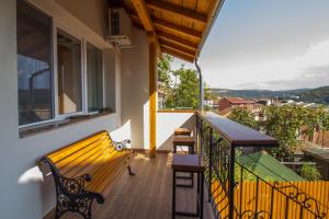 大特尔诺沃Tarno Guest House的阳台设有长凳和桌子。