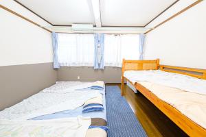 长崎渡邊民泊的一间卧室设有两张床和窗户。
