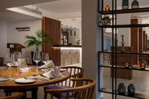 帕福斯Sofianna Resort & Spa的用餐室配有带酒杯的桌子