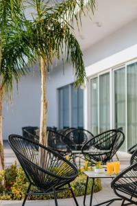 帕福斯Sofianna Resort & Spa的一组椅子和一张桌子,棕榈树