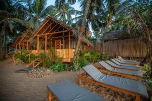 阿贡达Goa Cottages Agonda的度假村前一排躺椅