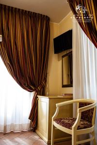 拉默齐亚泰尔默giardini del Novecento的椅子坐在窗前,有窗帘