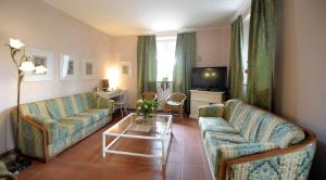 圣吉米纳诺贝尔韦德瑞别墅酒店 的客厅配有两张沙发和一台电视机