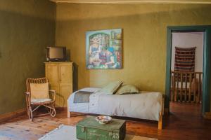 斯韦伦丹Bo Kapie(1833)的卧室配有一张床,墙上挂有绘画作品