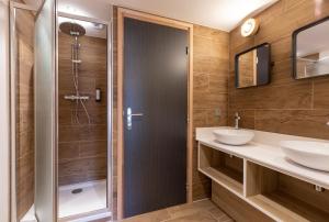 圣莫里斯堡Hotel Base Camp Lodge - Bourg Saint Maurice的带淋浴和两个盥洗盆的浴室
