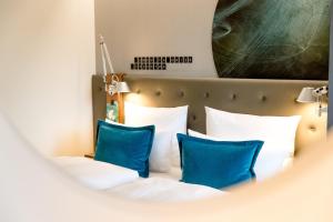 美因河畔法兰克福法兰克福机场1号汽车旅馆的配有蓝色枕头的床的酒店客房